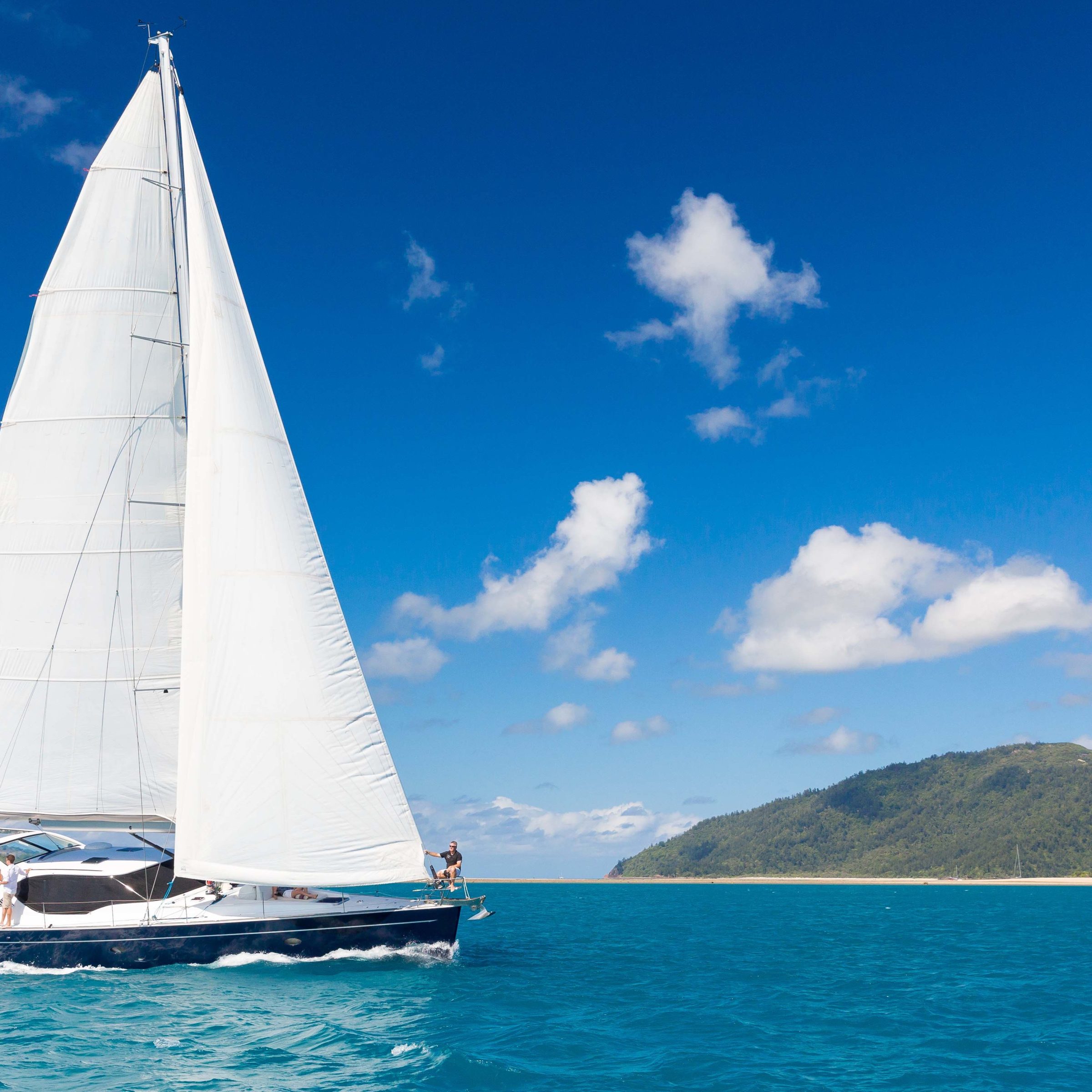 a blue and white boat sitting next to a body of water