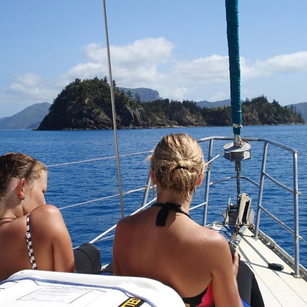 a person sitting on a dock next to a body of water