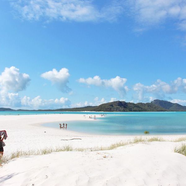 a group of people on a beach near a body of water
