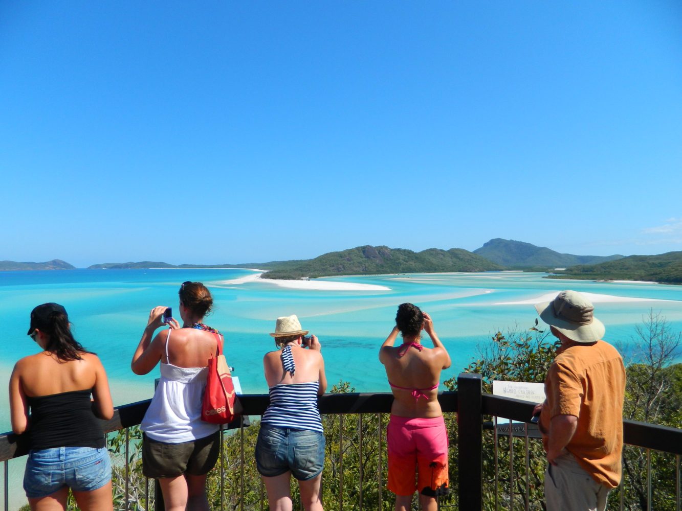 a group of people standing next to a body of water