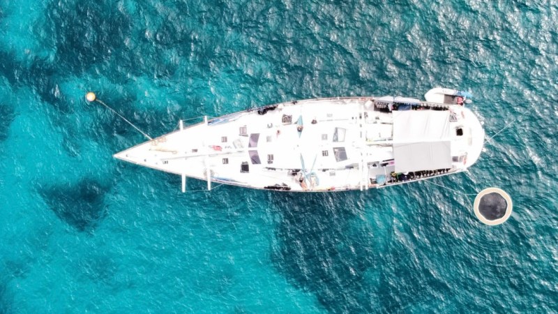 Aerial view of Summer Jo Sailing Vessel on clear blue ocean water.