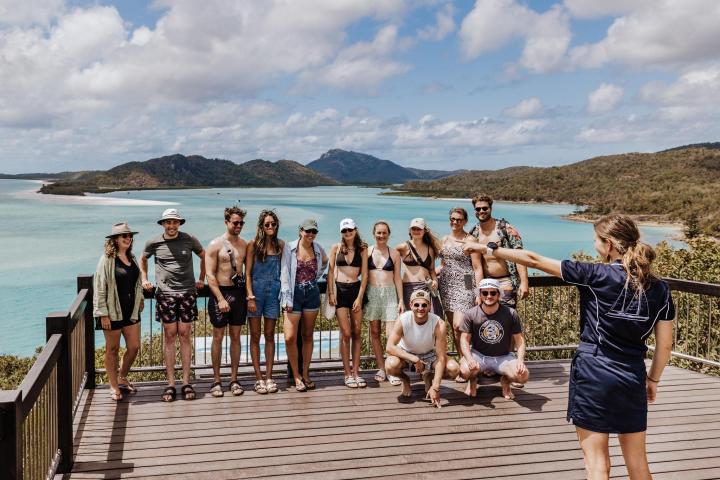 a group of people standing next to a body of water