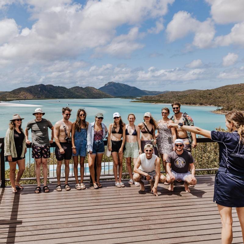 a group of people standing next to a body of water